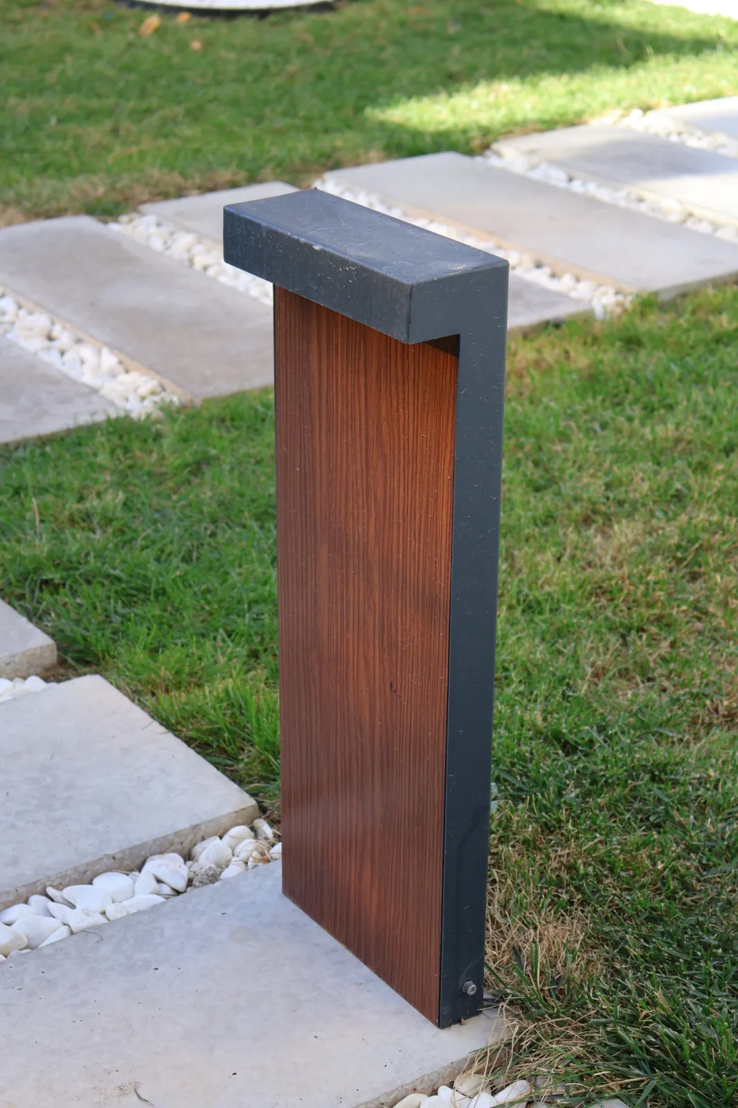Arca Konakları — Outdoor path bollards in wood and dark metal mark the approach through the garden.