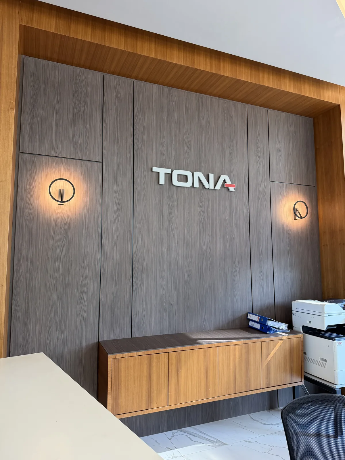 Tona Life — مكتب المبيعات: وحدتان جداريتان تؤطّران علامة Tona على الجوز.